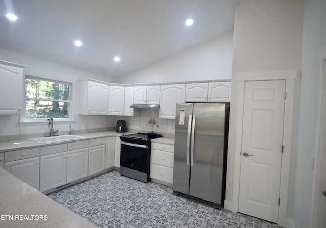 kitchen featuring stainless steel appliances, a sink, under cabinet range hood, white cabinetry, and vaulted ceiling