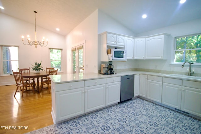 kitchen with white microwave, vaulted ceiling, dishwasher, a sink, and a chandelier