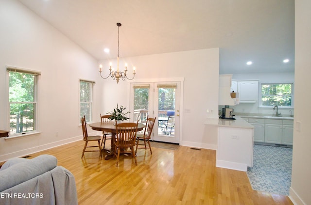 dining room featuring baseboards, a chandelier, light wood-style flooring, recessed lighting, and high vaulted ceiling