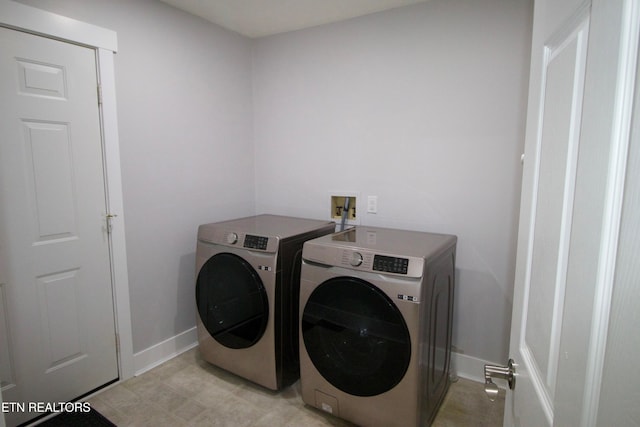 laundry area featuring separate washer and dryer and baseboards