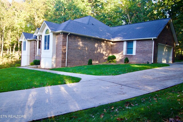 view of front of home featuring brick siding, a front yard, and concrete driveway