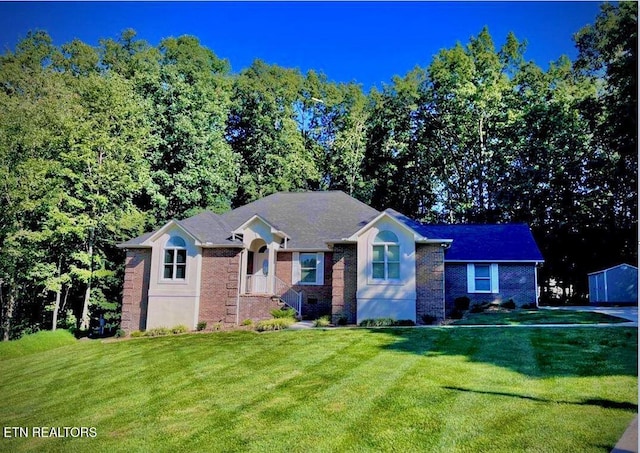 view of front of home with a front lawn and brick siding