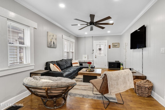 living area featuring ceiling fan, baseboards, wood finished floors, and crown molding