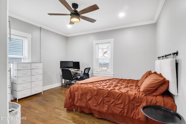 bedroom featuring dark wood-style floors, a ceiling fan, baseboards, and crown molding