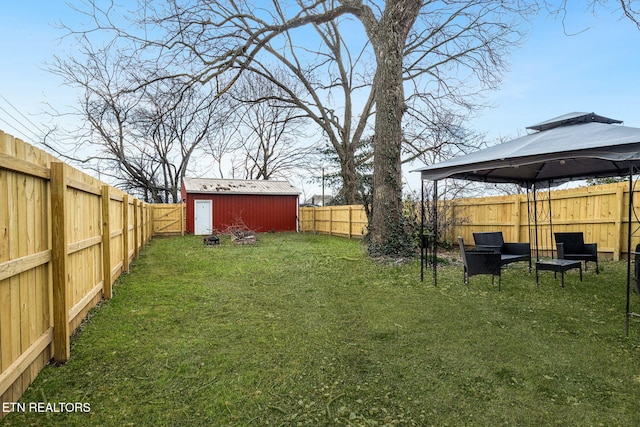 view of yard with an outbuilding, a gazebo, a storage unit, and a fenced backyard