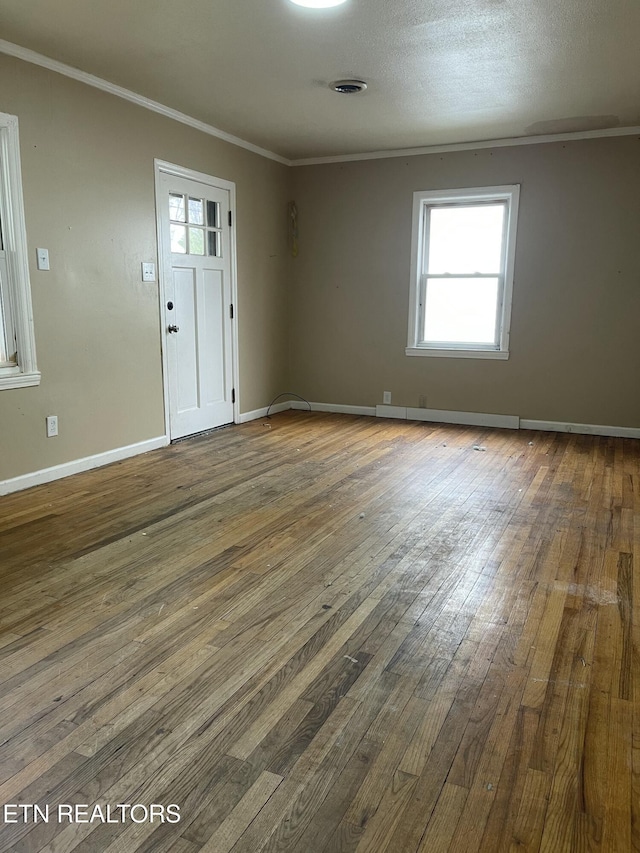 unfurnished room featuring ornamental molding, wood-type flooring, and a textured ceiling