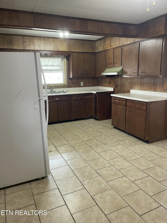 kitchen with sink, white refrigerator, and dark brown cabinetry