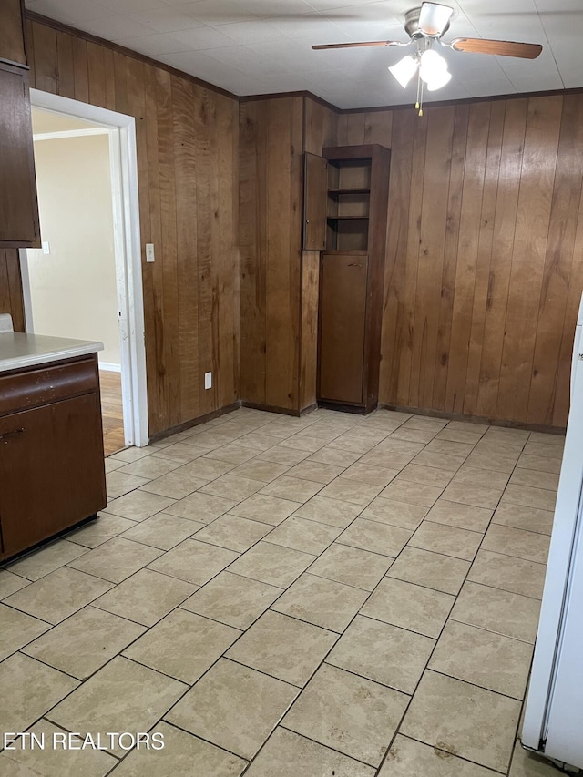 interior space featuring light tile patterned flooring, wood walls, and ceiling fan