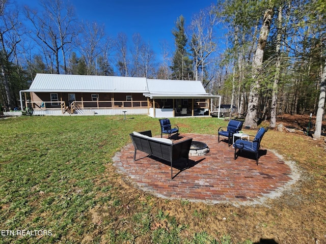 back of property featuring a yard and an outdoor fire pit