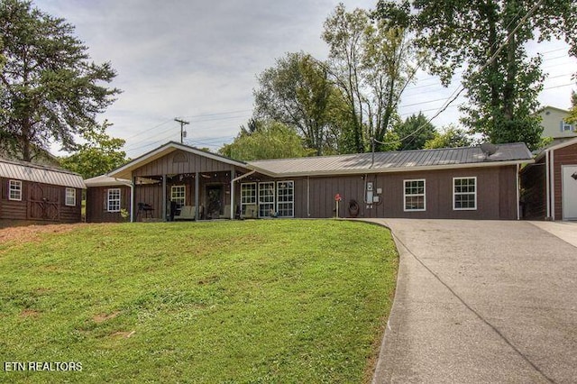 ranch-style home featuring a front yard and a storage unit