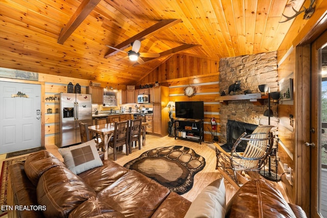 living room featuring wood ceiling, vaulted ceiling with beams, wood walls, a stone fireplace, and light wood-type flooring