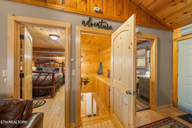 corridor featuring lofted ceiling, wood ceiling, and light hardwood / wood-style flooring