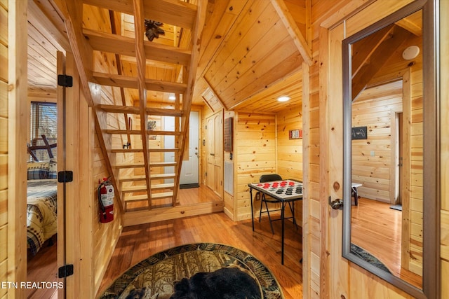 interior space featuring light wood-type flooring, wood ceiling, and wooden walls