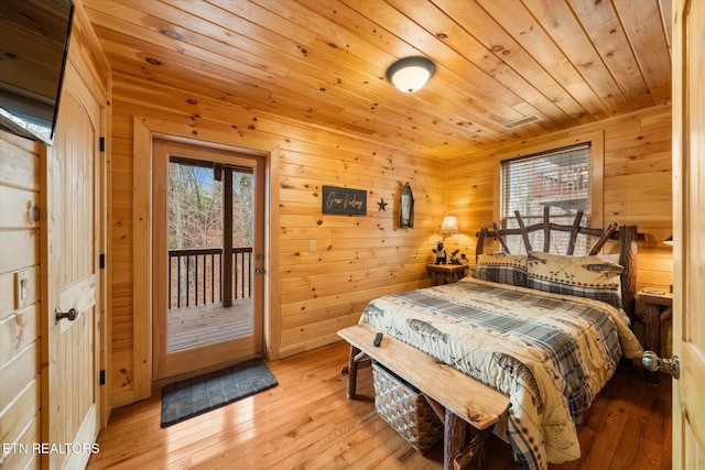 bedroom featuring wood walls, access to exterior, light hardwood / wood-style floors, and wooden ceiling