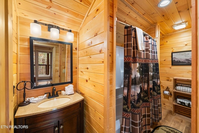 bathroom with hardwood / wood-style floors, vanity, curtained shower, wooden ceiling, and wood walls