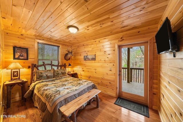 bedroom featuring wood ceiling, access to outside, wood-type flooring, and wood walls