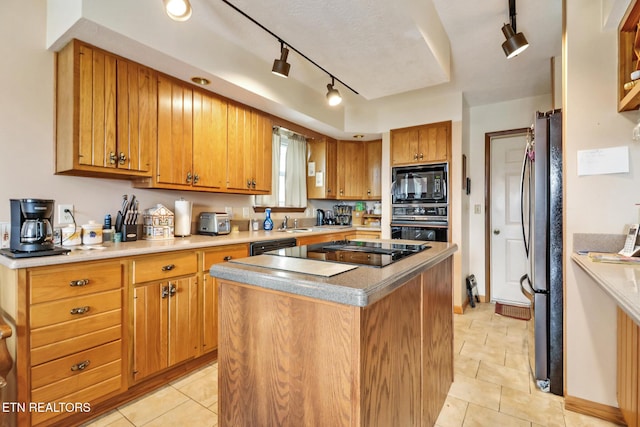 kitchen featuring light tile patterned flooring, sink, a kitchen island, and black appliances