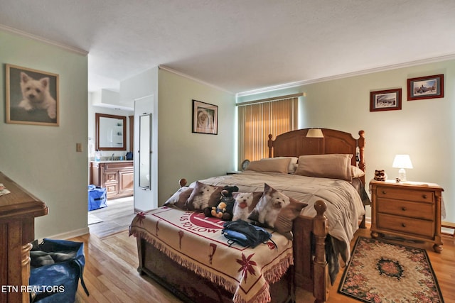 bedroom featuring sink, crown molding, ensuite bath, and light hardwood / wood-style floors