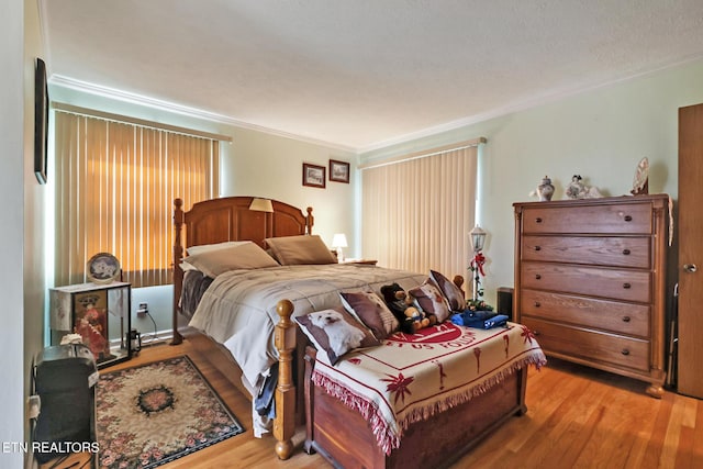 bedroom with crown molding and light hardwood / wood-style flooring