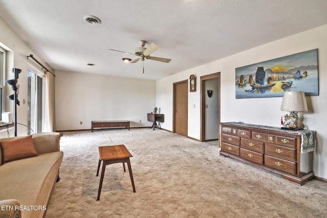 living room with light colored carpet, a textured ceiling, and ceiling fan