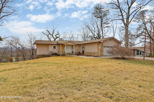 single story home featuring a garage and a front lawn