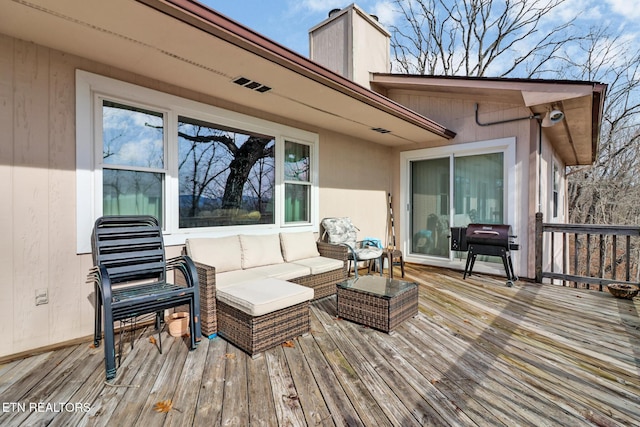 deck with an outdoor living space and area for grilling