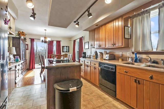 kitchen featuring sink, an inviting chandelier, a center island, hanging light fixtures, and dishwasher