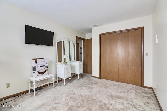 bedroom with light colored carpet and a closet