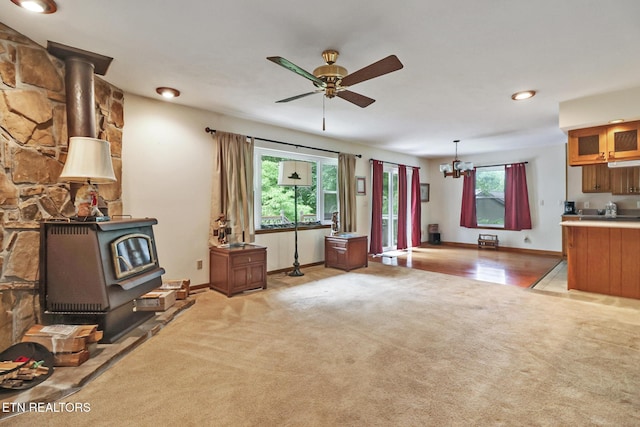 27 Brambleton Ct, Crossville, TN 38558 - living room with a wood stove, light colored carpet, a ceiling fan, and a chandelier