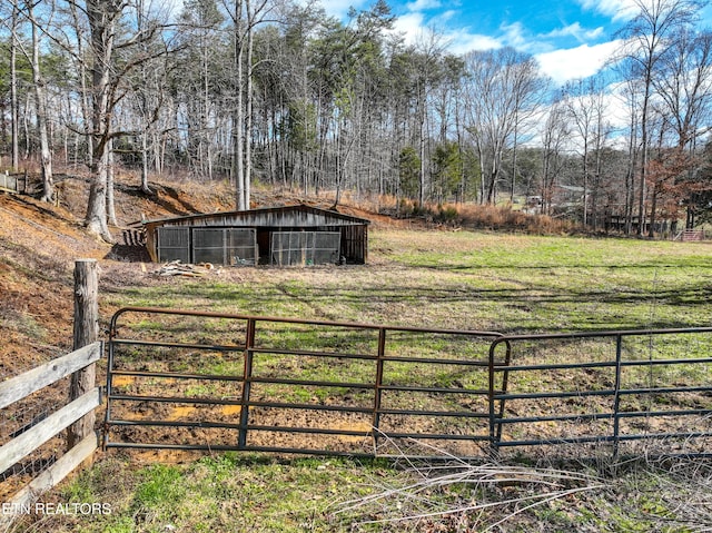 view of yard with fence, a pole building, and an outbuilding