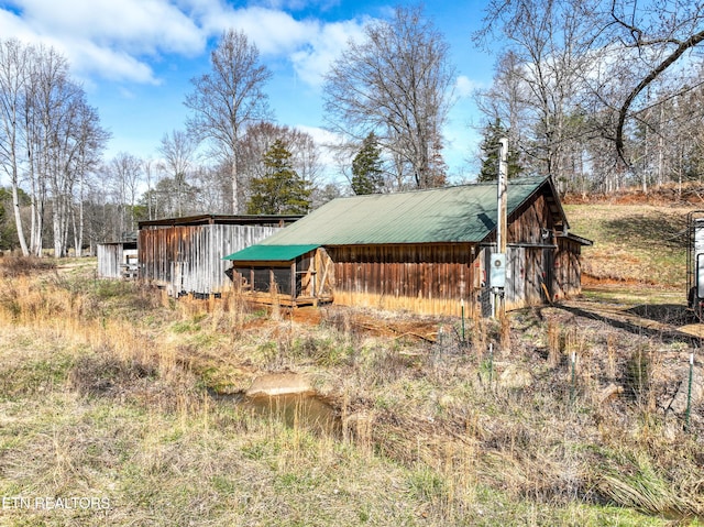 view of property exterior with an outbuilding and metal roof