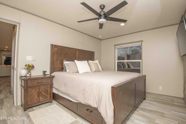 bedroom featuring ceiling fan, crown molding, and light wood finished floors