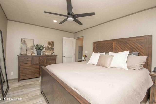 bedroom with light wood finished floors, ceiling fan, and ornamental molding