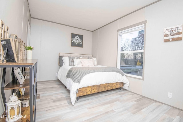 bedroom with light wood-style flooring and ornamental molding