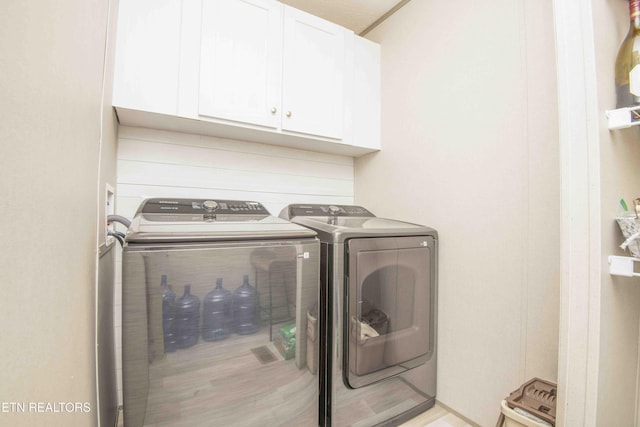 laundry area with cabinet space and separate washer and dryer