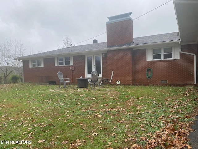 back of house featuring a lawn