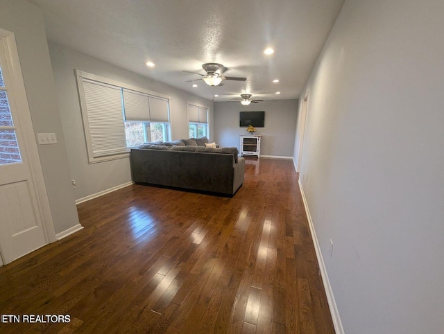 unfurnished living room with dark hardwood / wood-style floors and ceiling fan