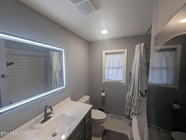 bathroom with vanity, tile patterned flooring, toilet, and walk in shower