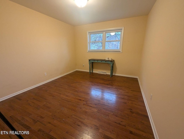 unfurnished room with dark hardwood / wood-style flooring