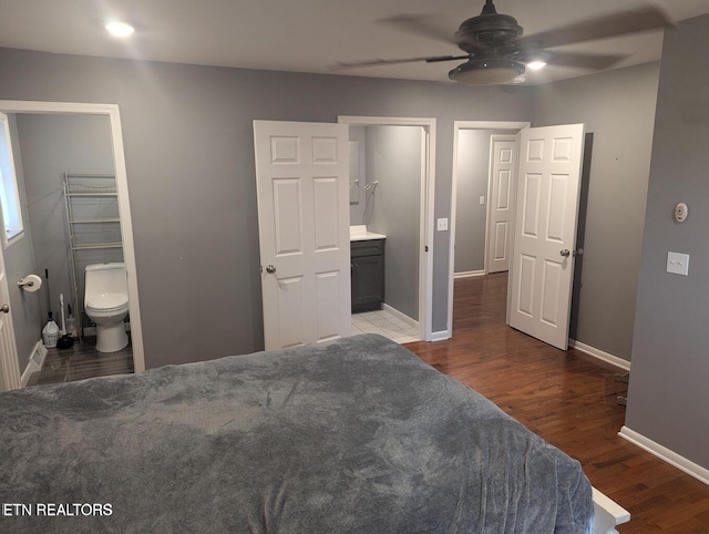 bedroom with ensuite bath and dark wood-type flooring