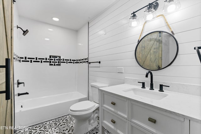 full bathroom with tile patterned flooring, wooden walls, vanity, tiled shower / bath, and toilet