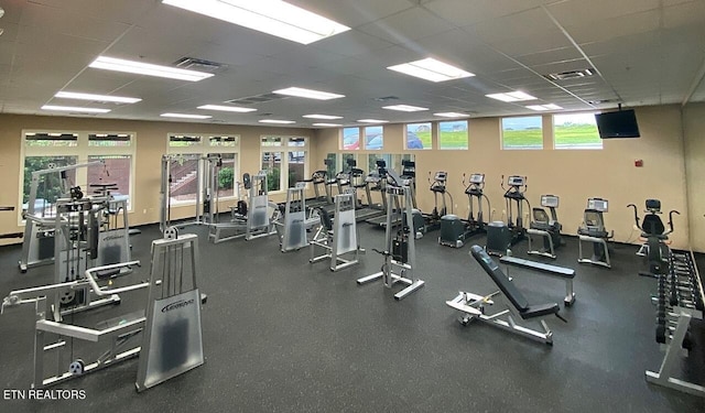 exercise room with a paneled ceiling and visible vents