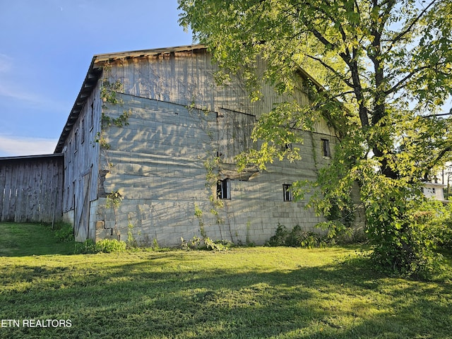 view of side of home with a yard and an outbuilding