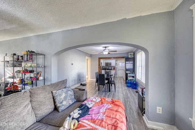 living room with ceiling fan, hardwood / wood-style floors, and a textured ceiling