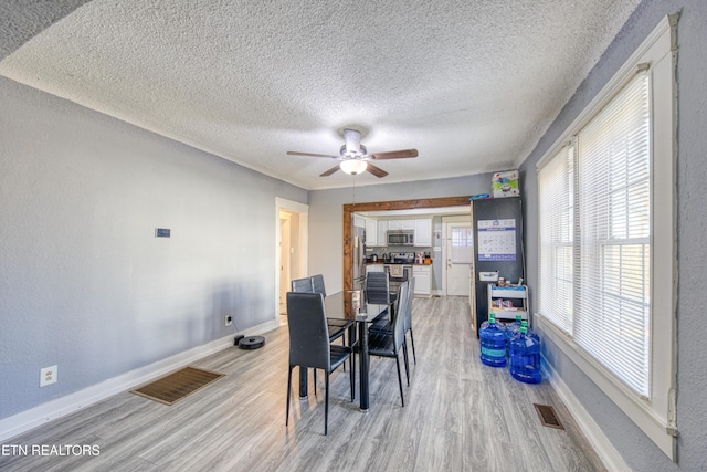 dining area featuring ceiling fan, a textured ceiling, and light wood-type flooring