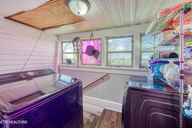 clothes washing area with wooden ceiling, independent washer and dryer, and wood walls