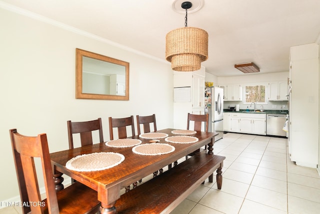 dining area with light tile patterned floors, crown molding, a notable chandelier, and sink