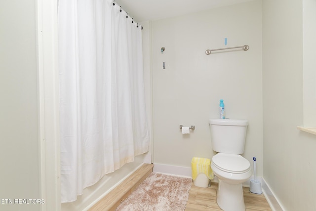 bathroom with hardwood / wood-style flooring, toilet, and shower / bath combo