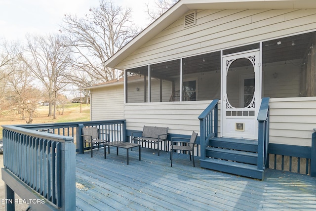 wooden deck with a sunroom