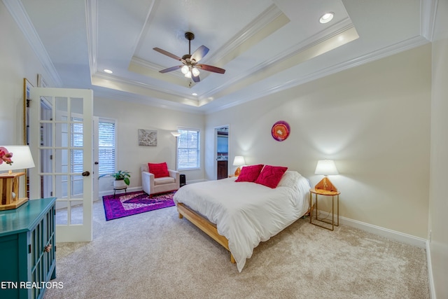 carpeted bedroom featuring a tray ceiling, ornamental molding, and french doors